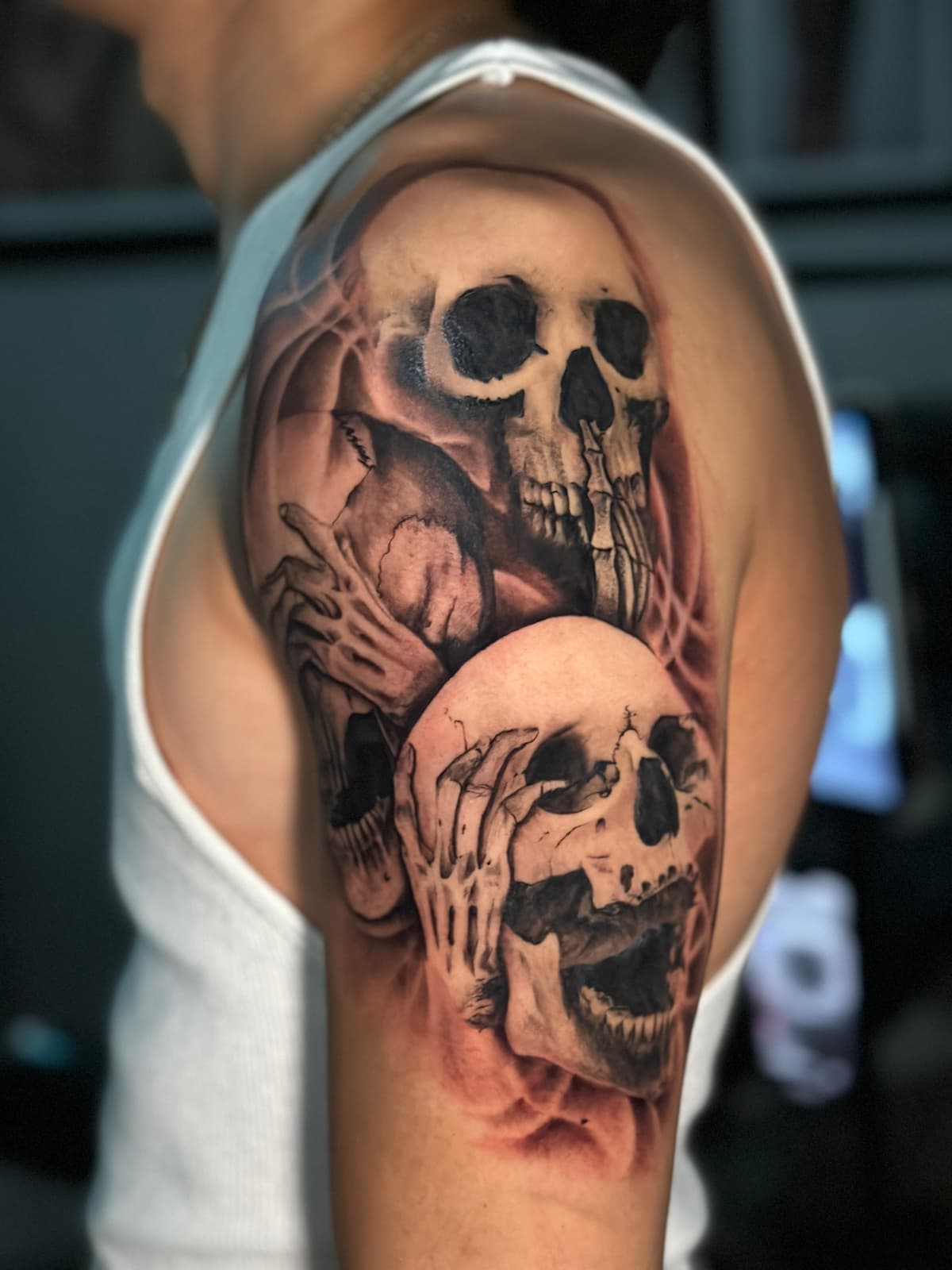 Three Skulls — Black and Grey / Upper arm, freehand smoke
